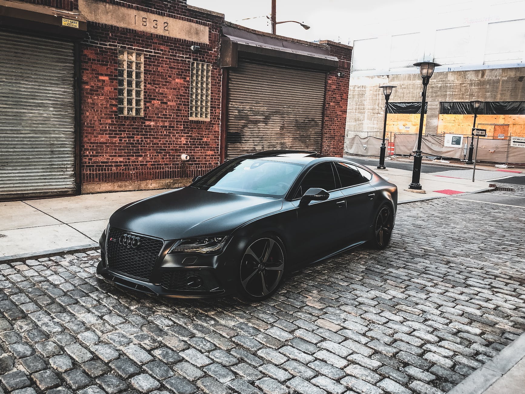 black audi a series parked near brown brick house